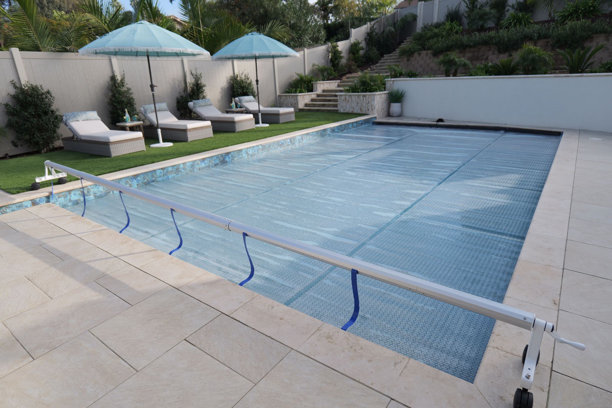Complete GeoBubble™ cover system on a customer pool — Sol+Guard™ cover, floating leading edge, and Rocky's Reel