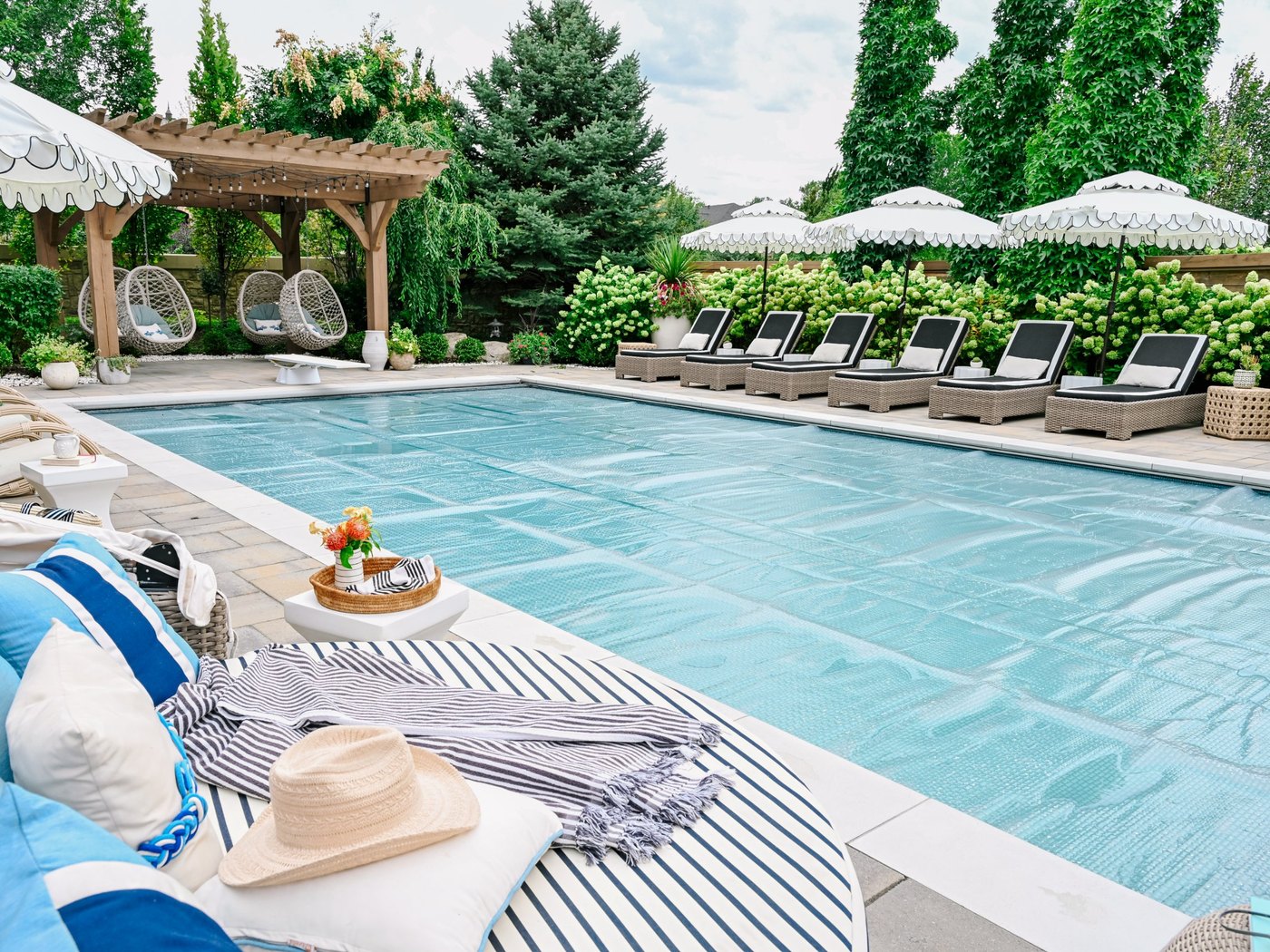 A GeoBubble cover on a backyard pool, lounge chairs along the far edge