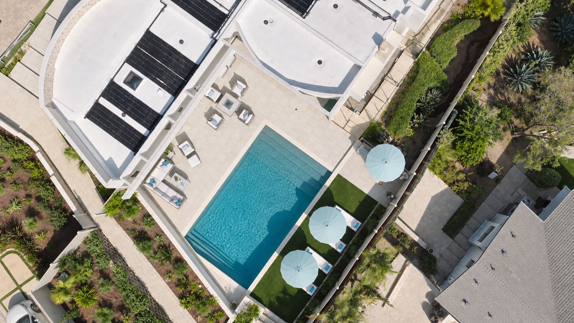 A backyard pool beside a roof-mounted solar heating system
